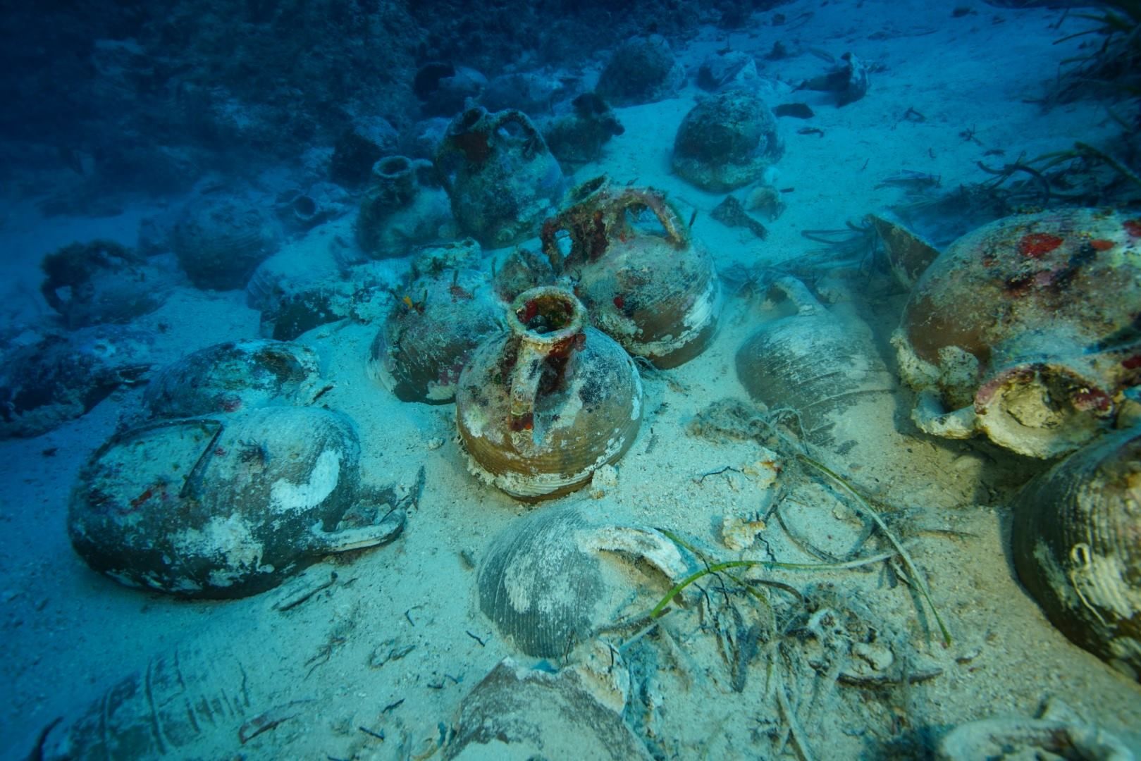  🏺🏺🏺 The image shows a pile of Roman shipwreck cargo amphorae lying on the seabed. 🏺🏺🏺