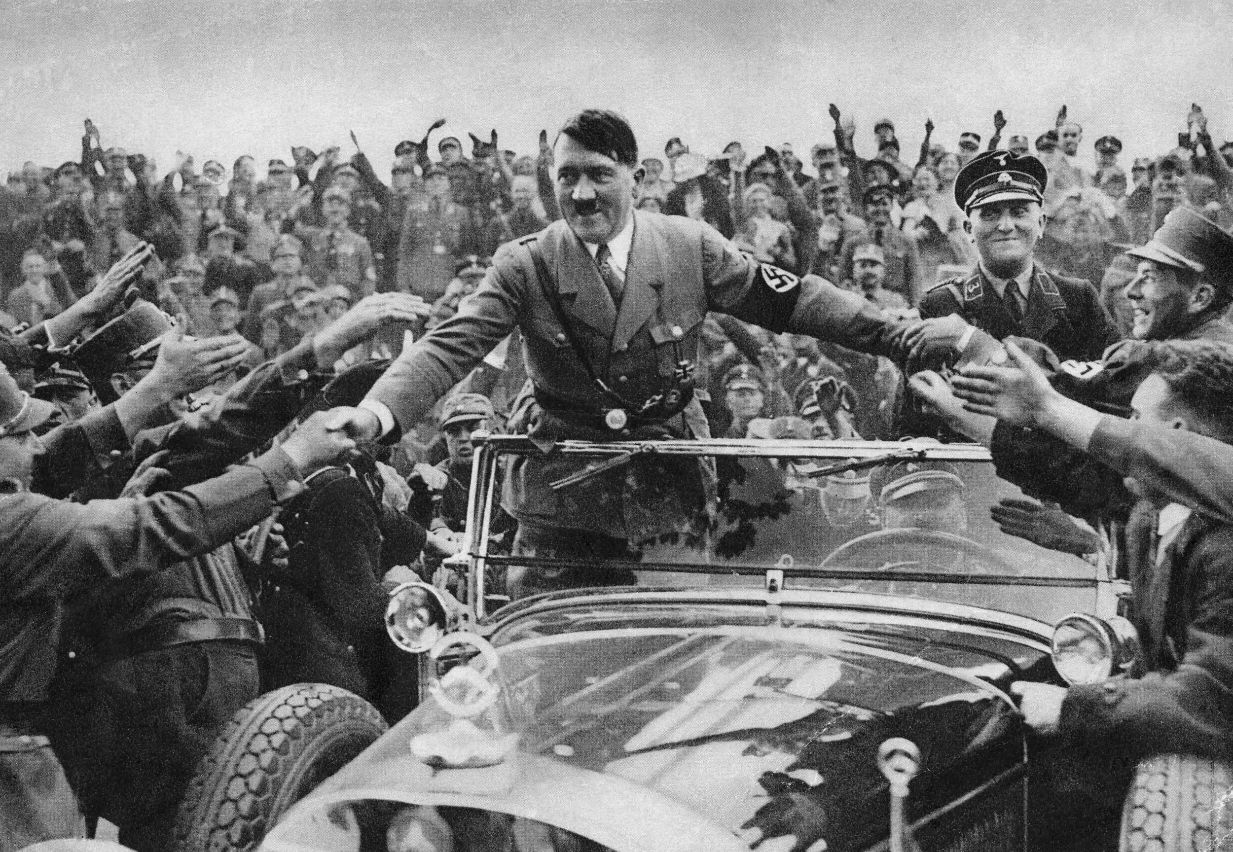 Hitler en un coche reuniendo a la gente hacia su visión del mundo en la Alemania nazi, prueba de su carismático liderazgo