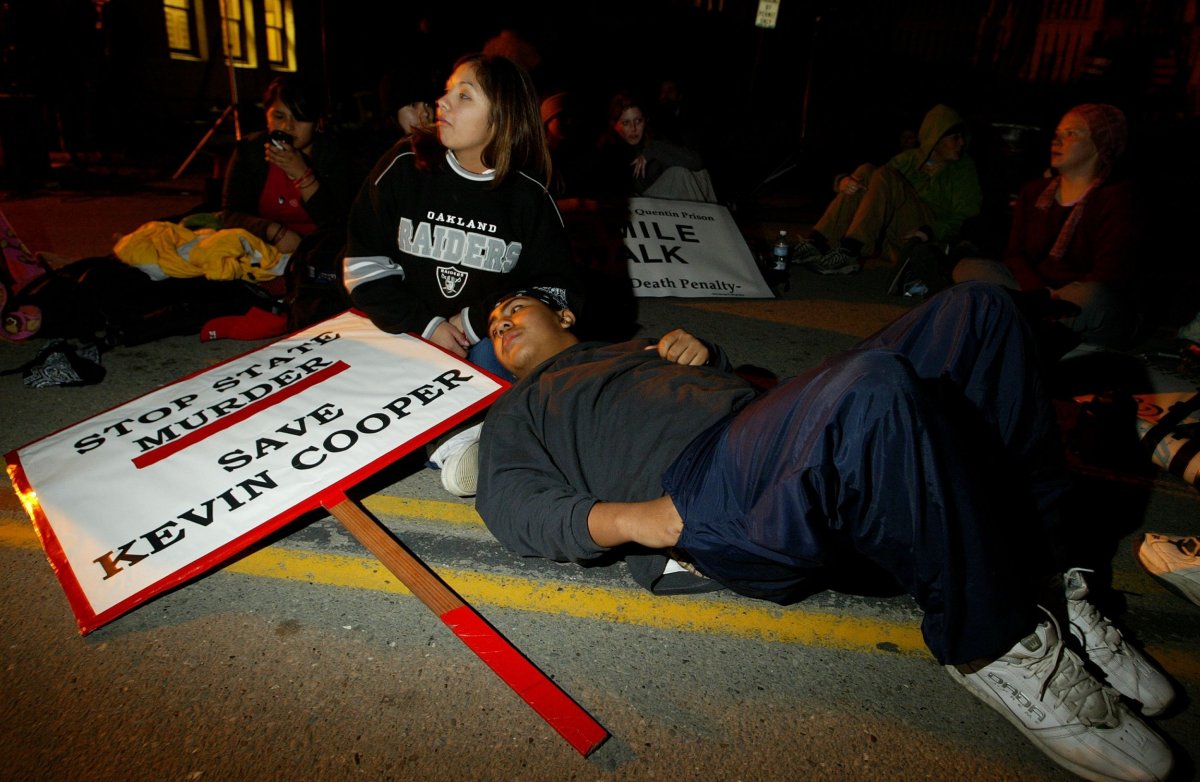 A couple rests outside of San Quentin State Prison in San Quentin, California, on February 9, 2004. They walked with other protestors from San Francisco in opposition to the execution of Kevin Cooper.