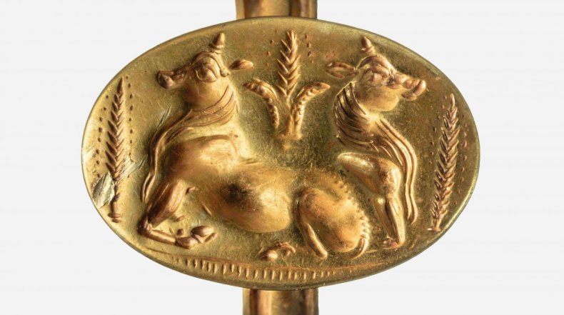 A gold ring depicts bulls and barley