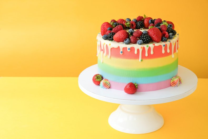 A rainbow cake on a cake stand