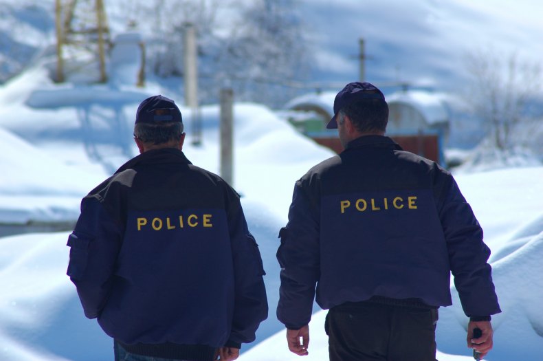 Two police officers walk in snow