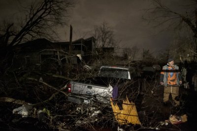 A man walks by a storm damaged pickup truck A man walks by a storm damaged pickup truck