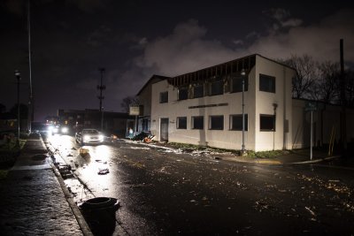Vehicles pass by damaged buildings on Jefferson St. Vehicles pass by damaged buildings on Jefferson St.