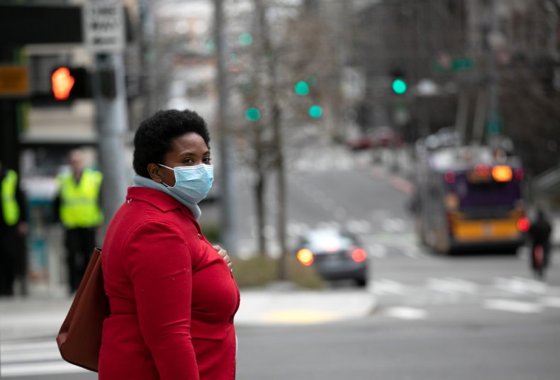 A masked pedestrian pauses near the Amazon headquarters A masked pedestrian pauses near the Amazon headquarters