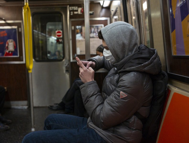 Man riding subway wearing a mask