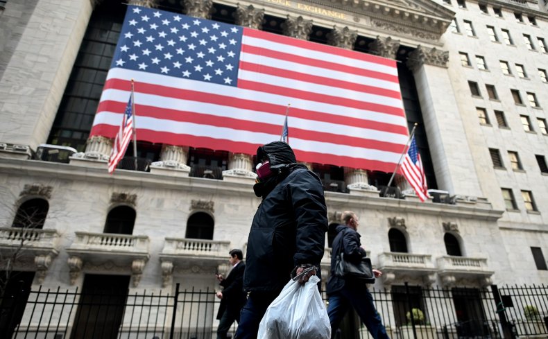 A man wearing a mask walks by the New York Stock Exchange (NYSE) on March 17, 2020 at Wall Street in New York City. 