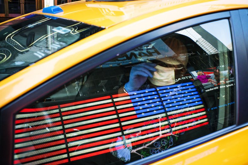A taxi driver wears a face mask and gloves as he drives down Times Square on March 26, 2020 in New York City.
