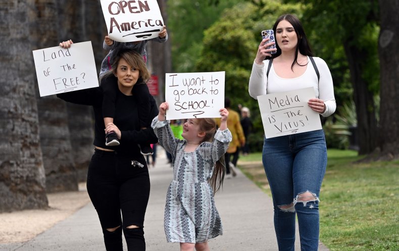 Family holds up signs protesting Coronavirus lockdown