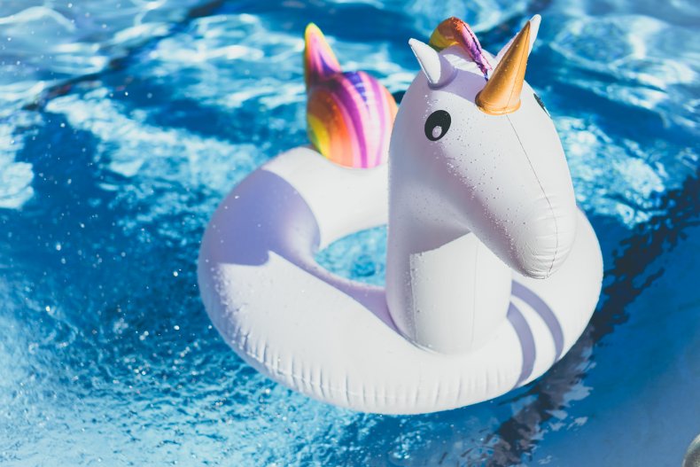 Inflatable colorful white unicorn at the swimming pool. 