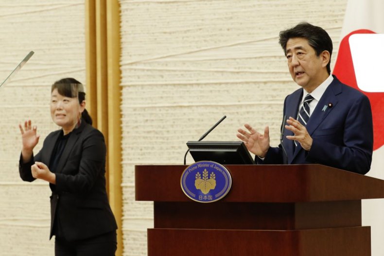 Japan's Prime Minister Shinzo Abe speaks as a sign language interpreter wearing a face shield interprets at a news conference in Tokyo on May 25. KIM KYUNG-HOON/POOL/AFP/GETTY