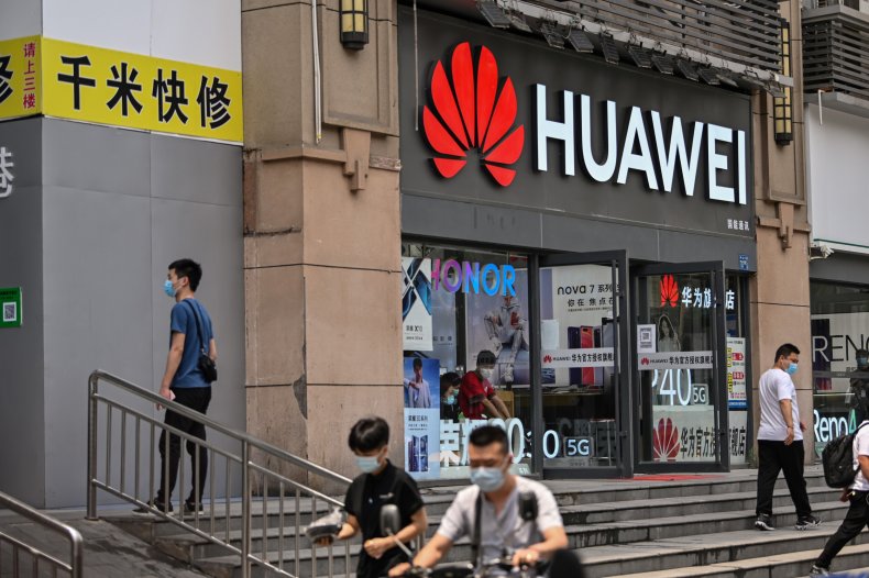 People walk past a Huawei store