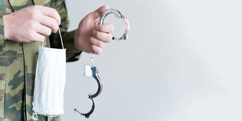Officer holding face mask and handcuffs