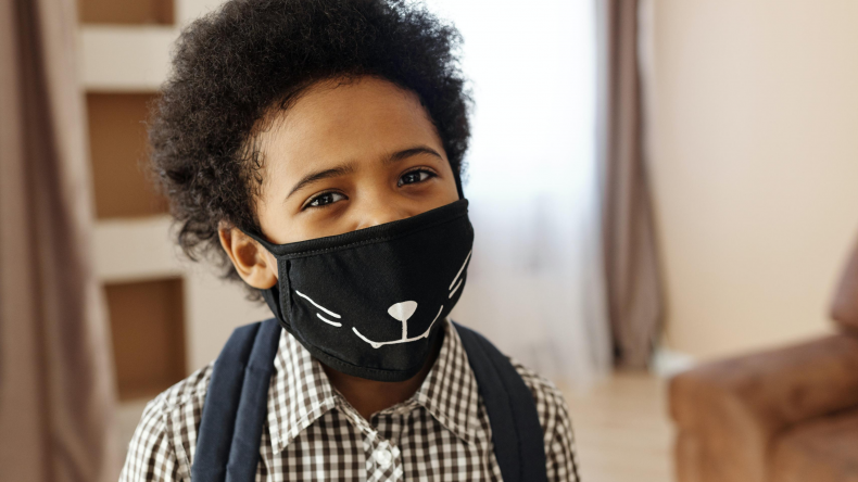 Boy wearing mask, smiling at camera