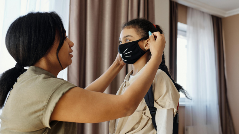 Mom putting mask on daughter