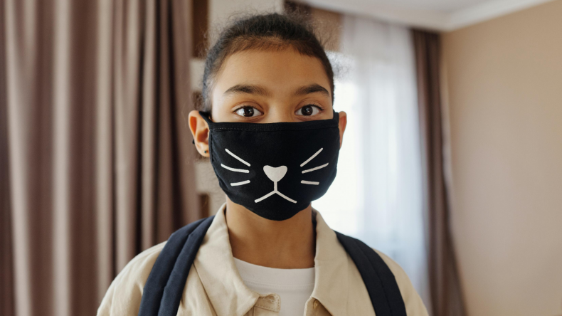 Young girl with mask on, smiling