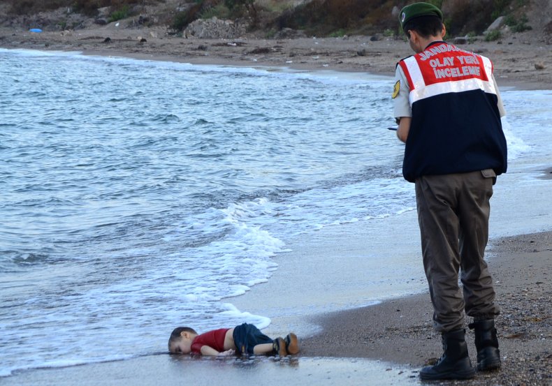 Turkish officer standing next to Alan Kurdi