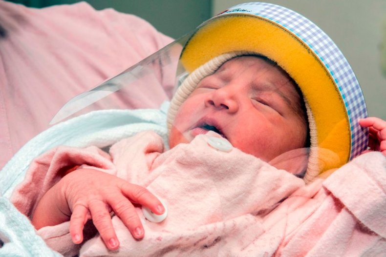 Newborn baby wears a face shield