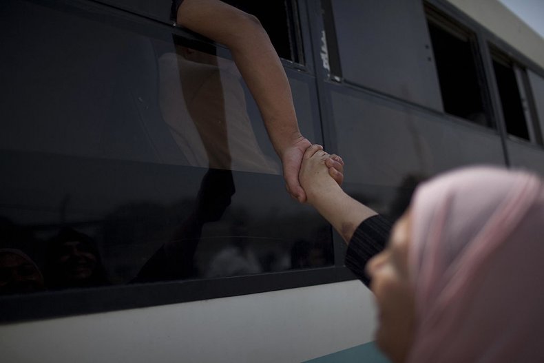 Woman separated holds hand through vehicle