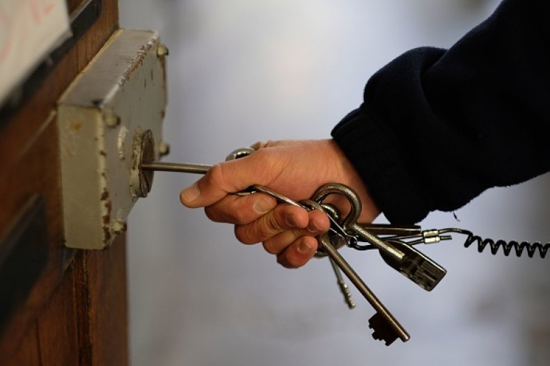 A prison guard opens a cell
