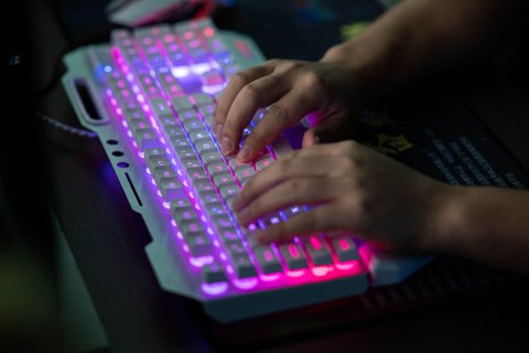 Person typing on backlit keyboard