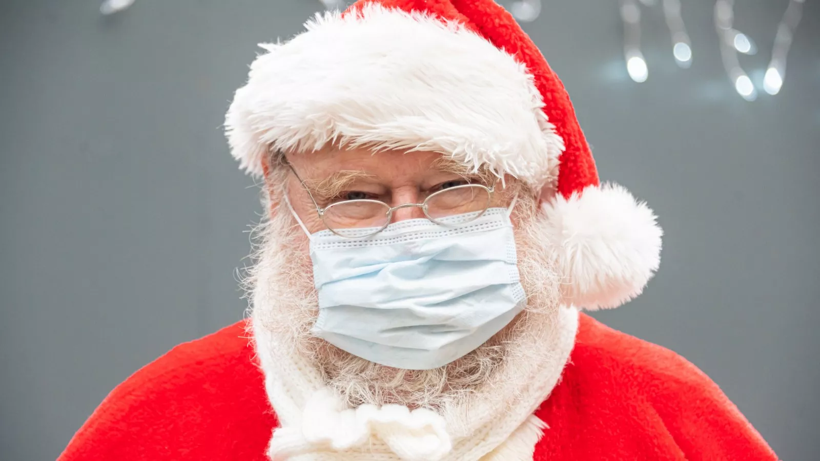Santa Claus wears a face mask covering while waiting for children