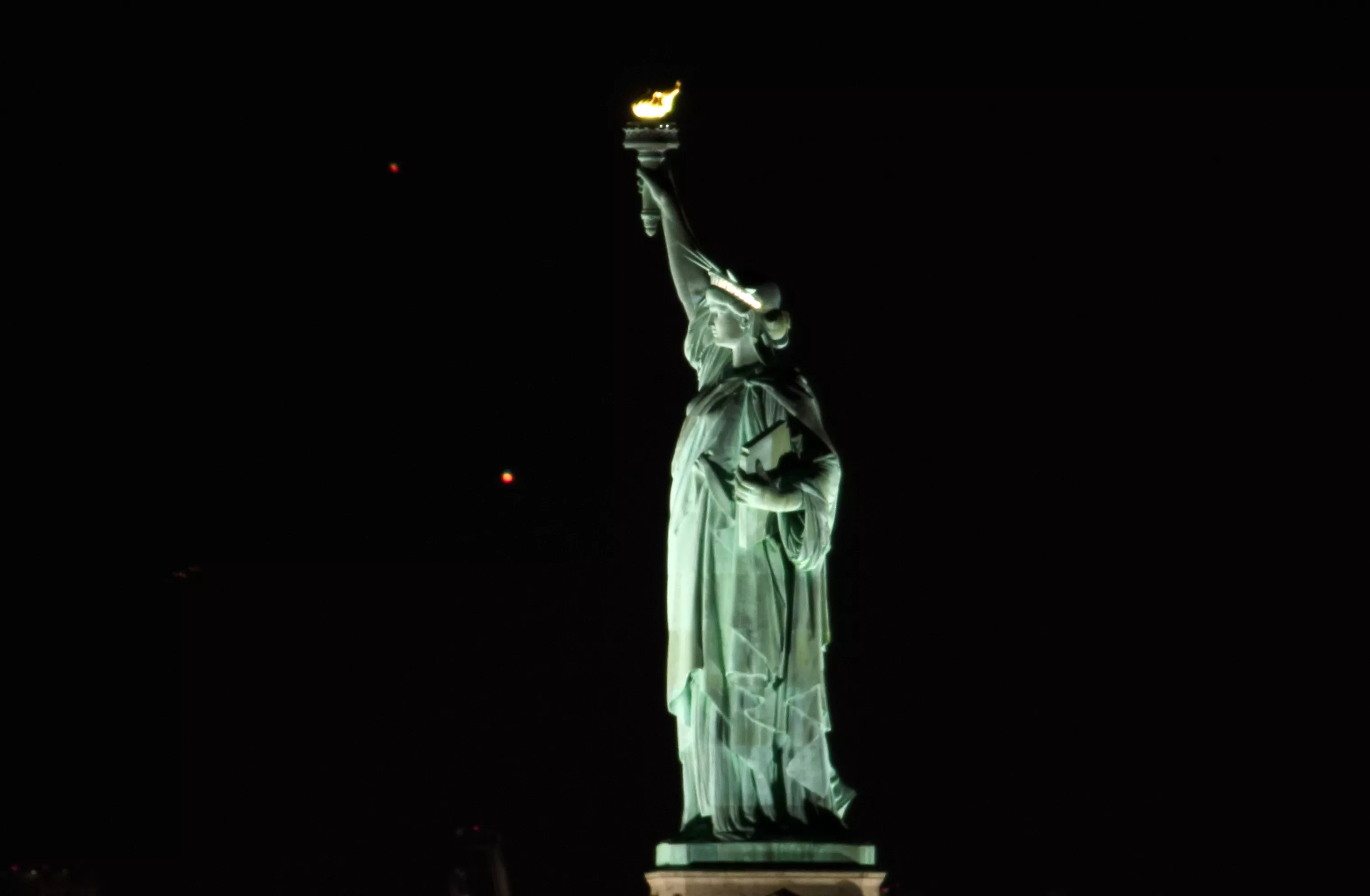 Saturn and Jupiter approach conjunction behind Statue of Liberty