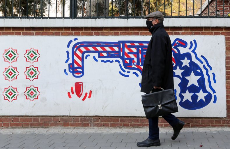 Iran man by US embassy mural Tehran