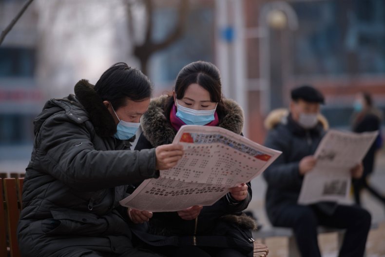 North Koreans read newspaper in Pyongyang