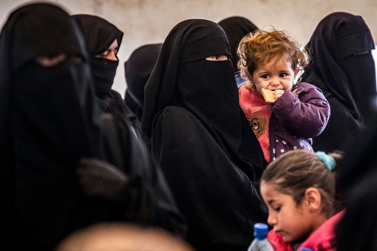 Women and children stand in Al-Hol camp