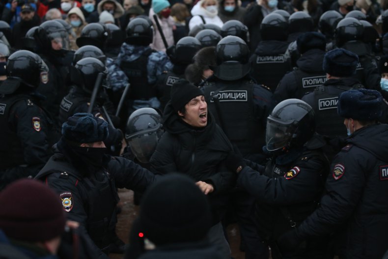 Russian policemen arrest a protester