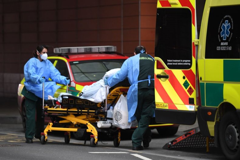 Paramedics wheel a patient from an ambulance
