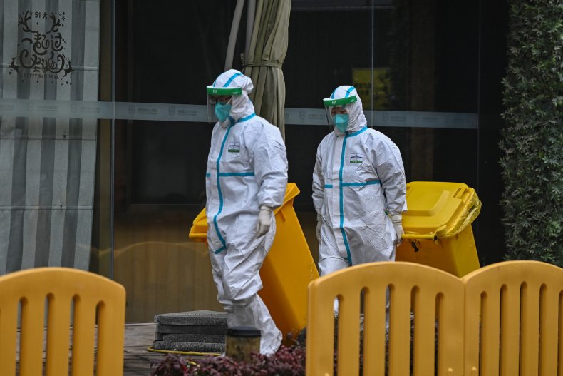 Workers wearing protective gear are seen in