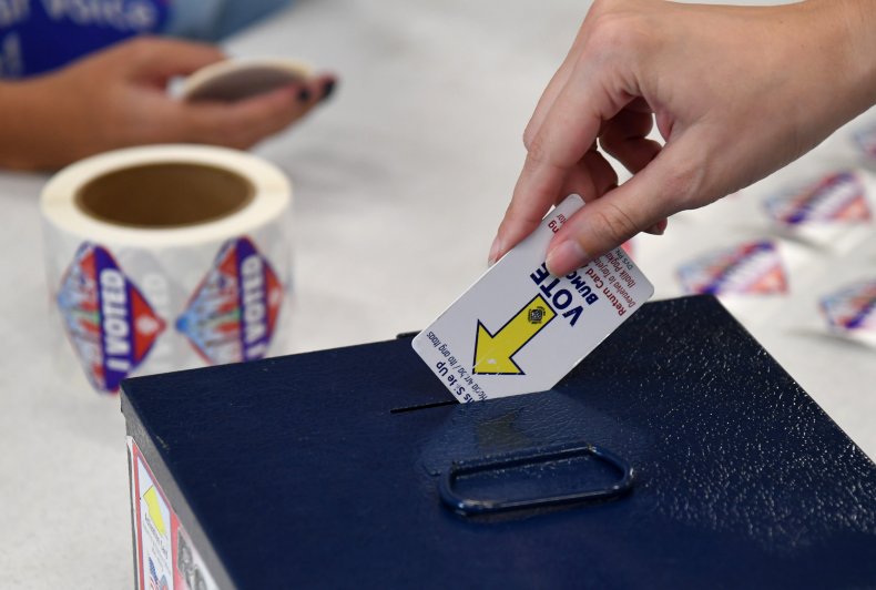 A voter returns an activation card after