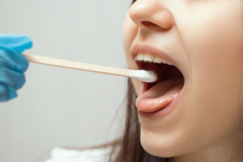 Health worker taking COVID-19 swab from child