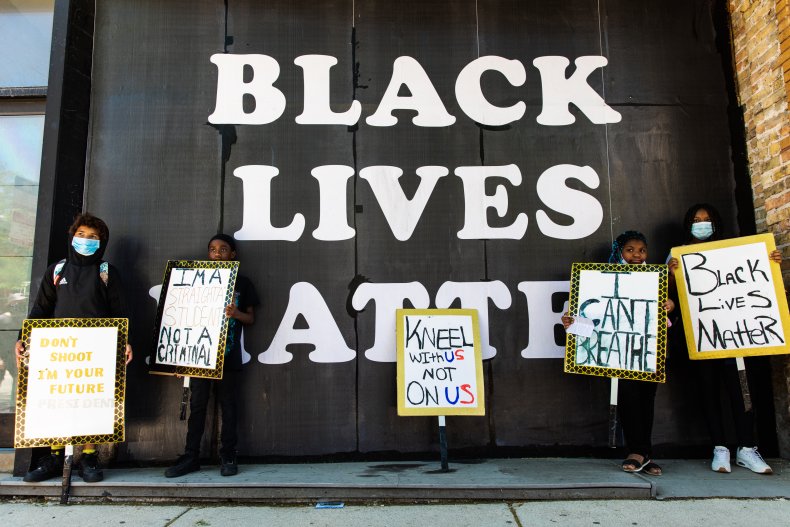 Family poses in front of BLM mural