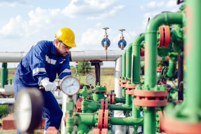 Worker adjusting gauge oil refinery