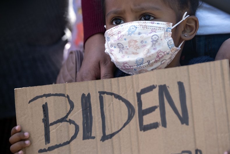 A Migrant Child Holds a "Biden" Sign