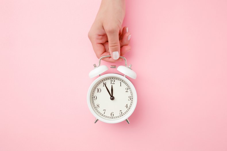 Person holding a clock