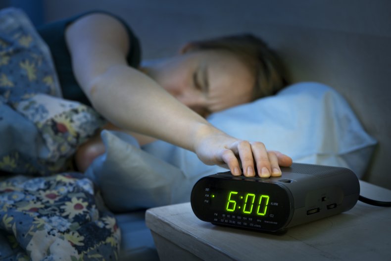Woman pressing a snooze button
