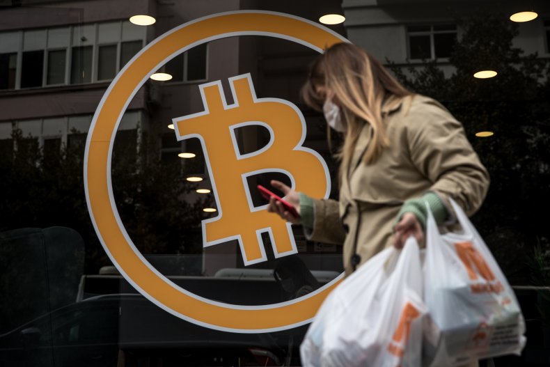 Woman walks past Bitcoin sign