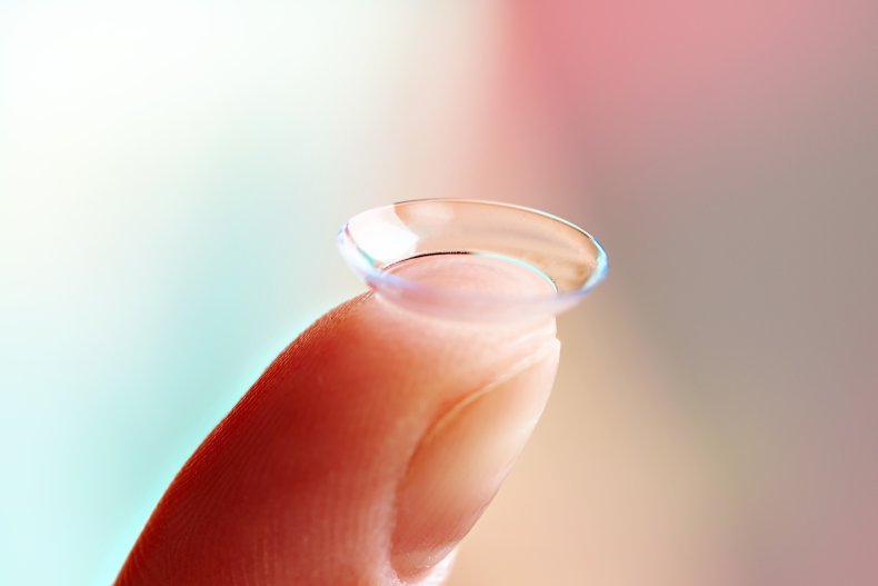 Woman's finger with contact lens.