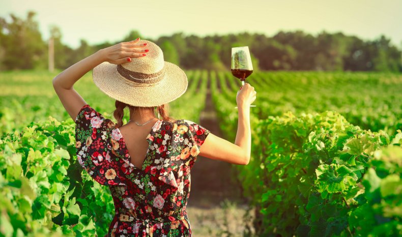 Woman drinking red wine at vineyard