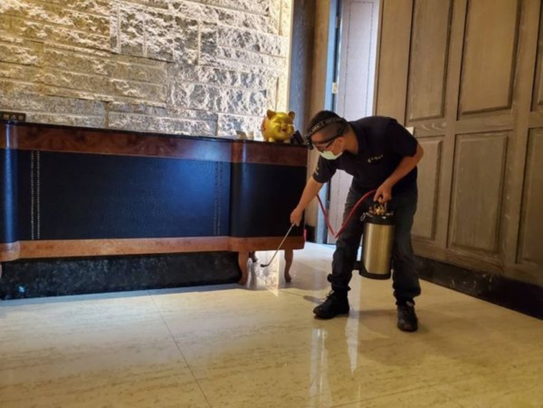 An inspector sprays pesticide to eliminate cockroaches.
