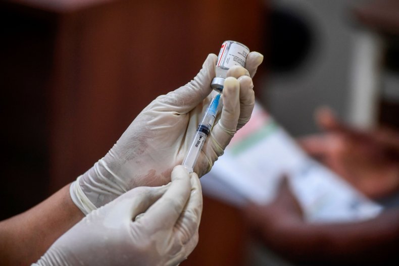 India health worker prepares vaccine dose
