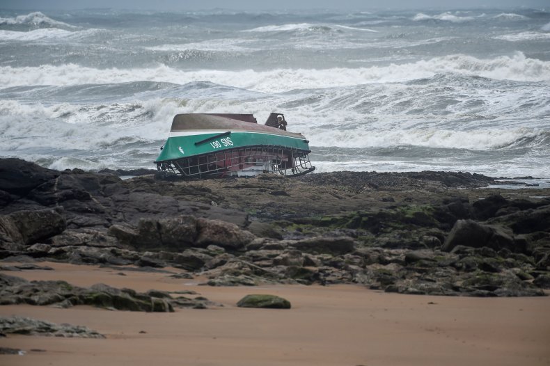 A capsized boat washes up on beach.