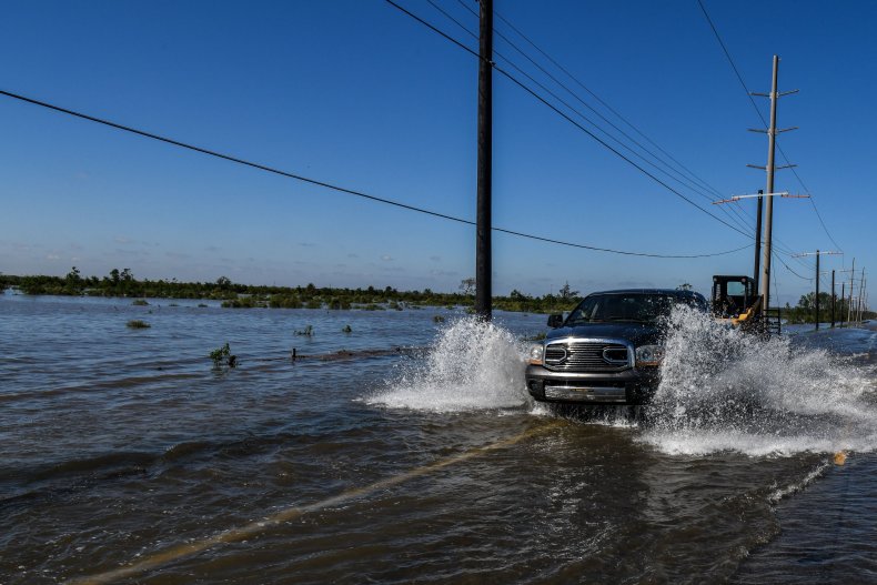 Car drives through flooded Louisiana street