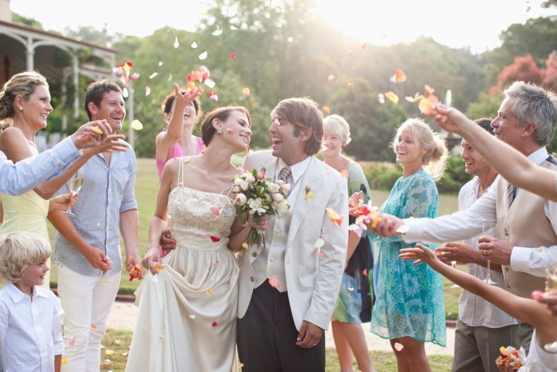guests throwing petals on bride and groom