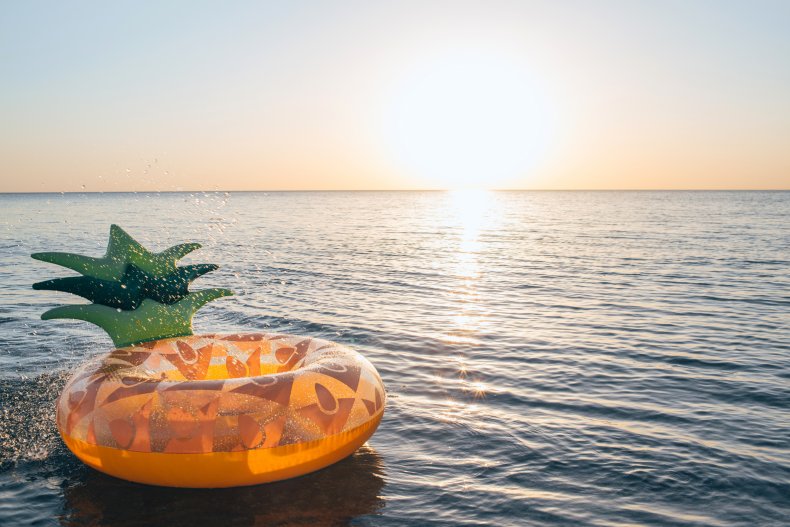 Inflatable pineapple floating in sea.