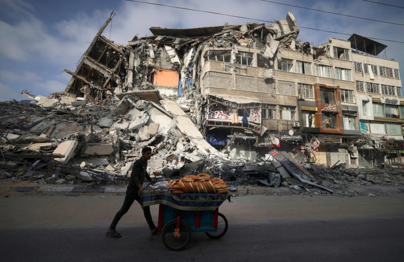 A man walks past a destroyed buildingi
